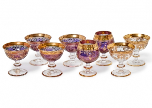 8 גביעי זכוכית בדגמים שונים מעוטרים בזהב חלקם על רקע סגול