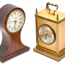 זוג שעוני שולחן בסגנון קלאסי, אחד עשוי מתכת מוזהבת והשני עשוי עץ