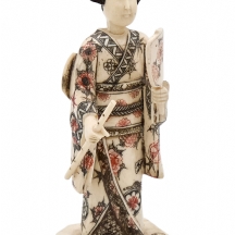 פסל דמות גיישה מעוטר בצביעה פוליכרומית עדינה לבושה קימונו מעוטר ומחזיקה מניפה