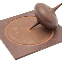 פסל שולחני עשוי ברזל יצוק בצורת סביבון ומשטח חתום