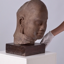 פסל ראש מרשים עשוי חומר יצוק בגימור דמוי אבן ובסיס עץ