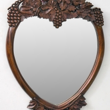 מראה בצורת לב עשויה עץ מעוטרת בגפנים וענבים